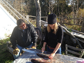 Learning to clean fish from harvester, Alex Stephens, while collecting samples in Fort Albany First Nation.